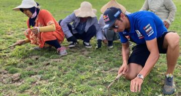 Toprak Razgatlioglu, pembalap tim PATA Yamaha yang menjadi juara dunia WSBK 2021 sedang 'ngarit' rumput bersama warga lokal di sekitar Sirkuit Mandalika 