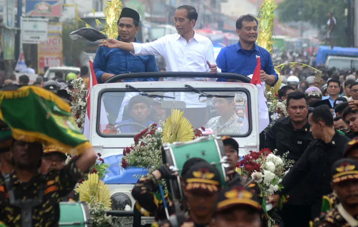 Presiden ke-7 Indonesia Joko Widodo (tengah) didampingi Calon Gubernur dan Calon Wakil Gubernur Jawa Tengah nomor urut 2 Ahmad Luthfi (kanan) - Taj Yasin (kiri) membagikan kaos dari mobi Jip saat pawai di Jalan Raya Tegal-Purwokerto, Kabupaten Tegal, Jawa Tengah, Sabtu (16/11/2024). Pawai sepanjang tiga kilometer itu dihadiri ribuan para pendukung Ahmad Luthfi-Taj Yasin dari berbagai daerah. 