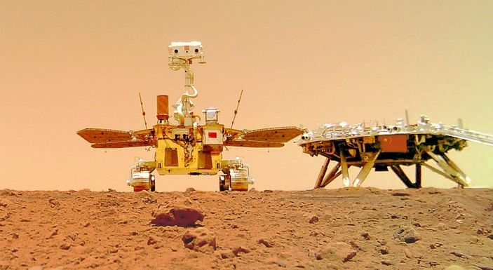 Rover Zhurong (kiri) menjelajah permukaan planet Mars.