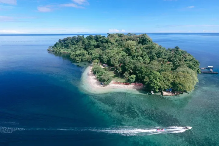 Pantai pasir putih Pulau Dutungan dengan air laut biru jernih