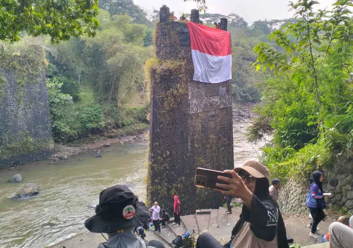 Bendera Raksasa Berkibar di Puing Jembatan Karang Resik