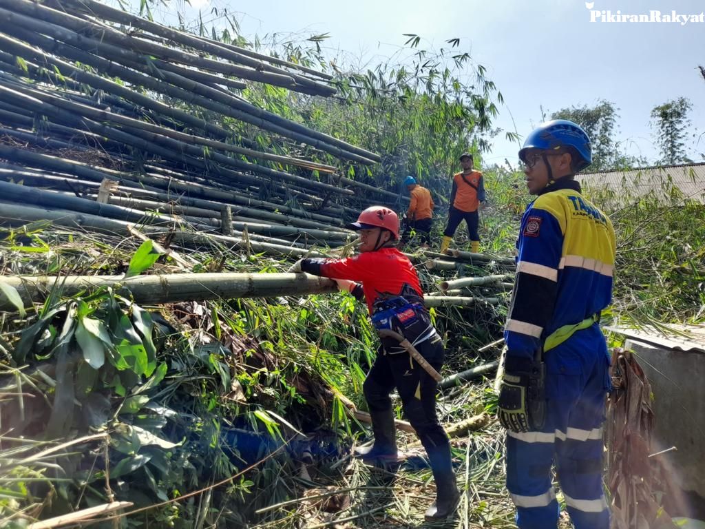 PETUGAS berupaya membersihkan sisa meterial reruntuhan rumpun bambu dan bagunan yang tersapu hujan disertai angin kencang di Desa Sukaharja Kecamatan Sariwangi Kabupaten Tasikmalaya, Minggu 19 Maret 2023.