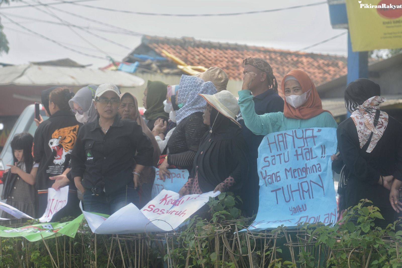 WARGA berdiri (kanan) sembari memegang kertas bertuliskan pendapatnya saat berunjuk rasa di depan Masjid Raya Al Jabbar, Gedebage, Kota Bandung, Senin, 20 Maret 2023. Sejumlah warga Gedebage Raya itu menyampaikan sejumlah tuntutan kepada Pemerintah Provinsi Jawa Barat. 