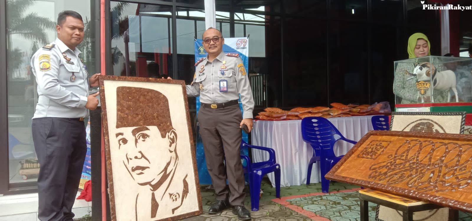  Kalapas Kelas IIB Garut, Iwan Gunawan Wahyudi didampingi Kasubsi Kegiatan Kerja Lapas Kelas IIB Garut, Egis Fantasi, menunjukan salah satu produk kerajinan tangan warga binaan Lapas Garut yang dipamerkan pada kegiatan One Day One Prison Product di halaman Lapas Kelas IIB Garut.