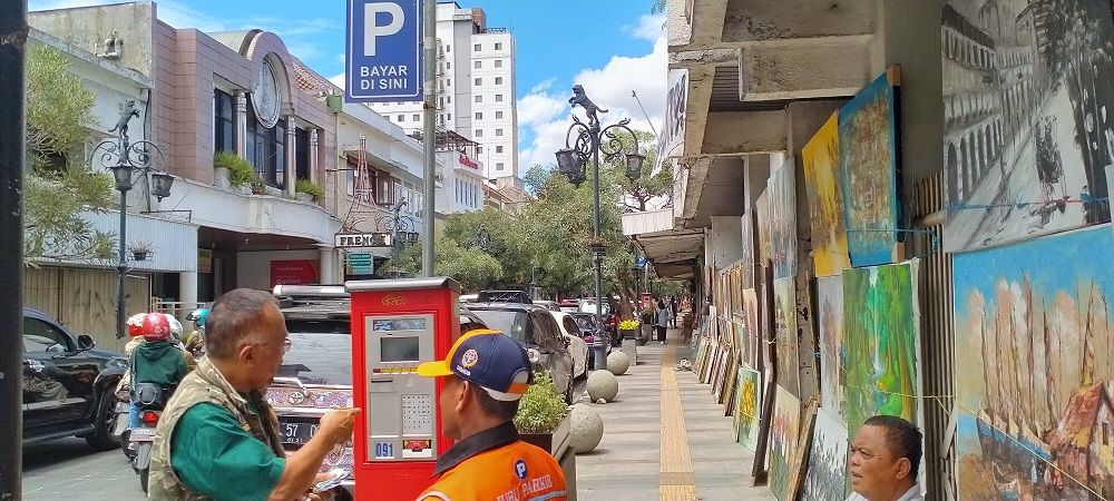 DODI (62), pengguna layanan mesin parkir menggunakan kartu petugas parkir agar bisa memarkirkan kendaraannya di Jalan Braga, Kota Bandung, Minggu, 12 Januari 2020.*
