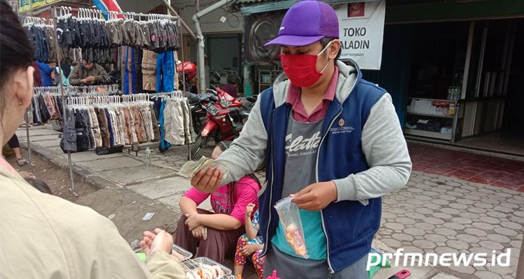 Salah seorang pedagang di Pasar Tumpah Margaasih, Kabupaten Bandung sedang melayani warga yang membeli jajanan, Minggu (15/3/2020) *Budi Satria/PRFM