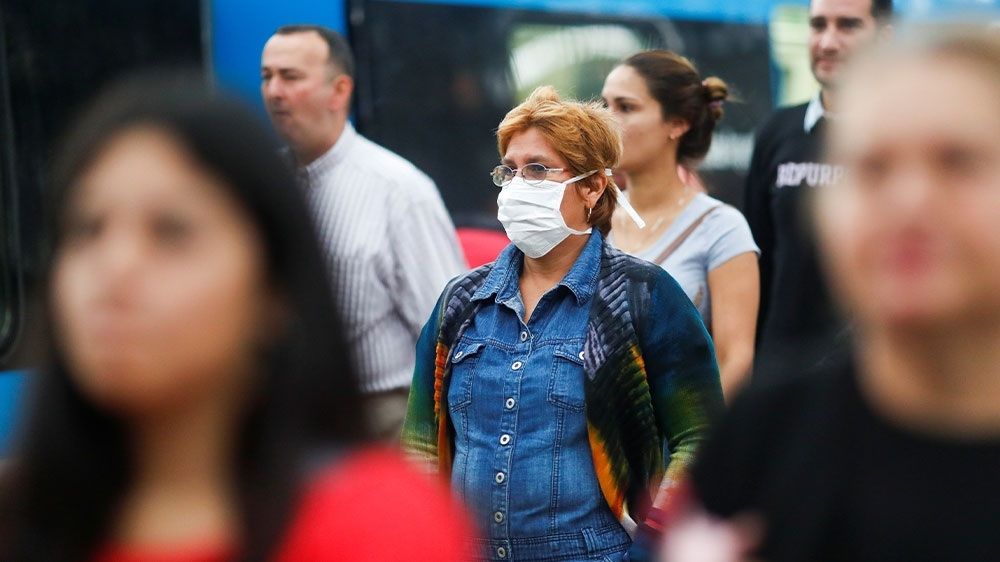 SEORANG wanita mengenakan masker pelindung saat berjalan di dekat stasiun kereta, di Buenos Aires, Argentina.*