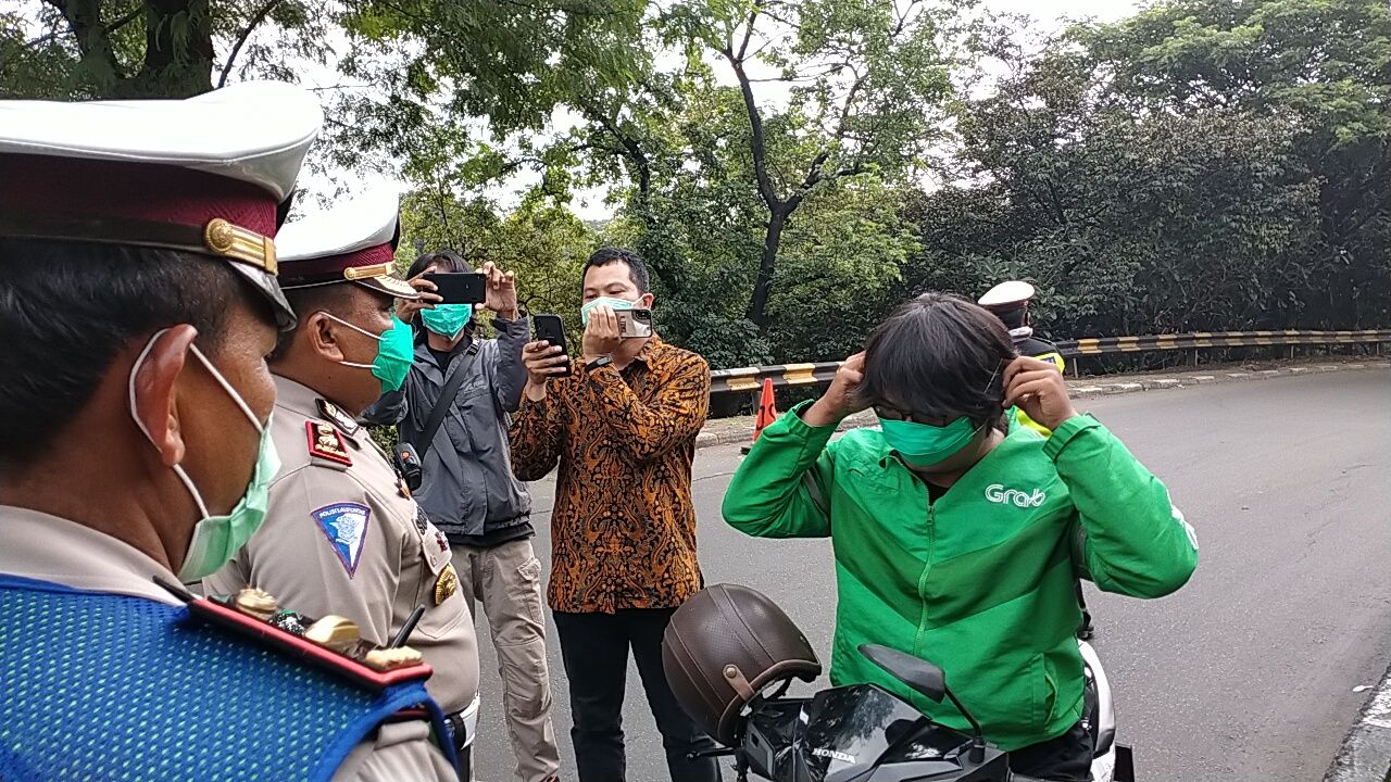 POLRES Metro Depok ikut menyediakan masker bagi pengemudi ojek online yang masih harus bekerja.*