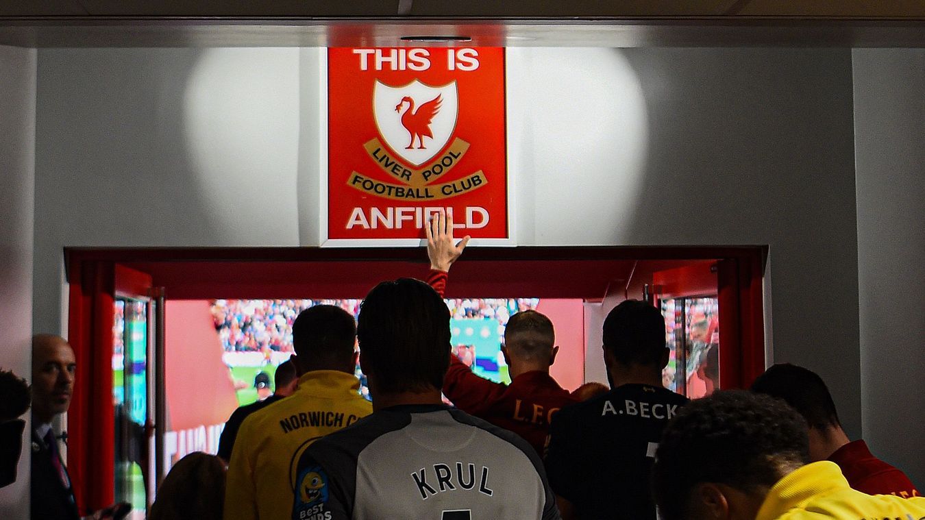 Liverpool 4-1 Norwich City. Kapten Liverpool Jordan Henderson menyentuh tanda 'This Is Anfield' ketika tim-tim keluar untuk pertandingan pertama 2019/20.
