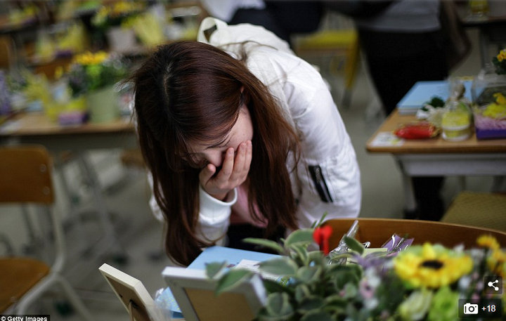 ORANG Tua dan masyarakat Korea Selatan tengah mengunjungi meja korban Feri Sewol, sembari menangis, menaruh bunga dan surat