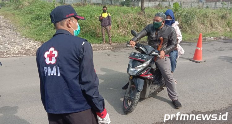 Petugas melakukan pemeriksaan kepada warga yang melintas check point Patrol di Kecamatan Kutawaringin, Kabupaten Bandung, Minggu (3/5/2020).*