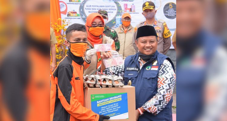 Wakil Gubernur Jawa Barat Uu Ruzhanul Ulum menyerahkan bantuan kepada warga Kabupaten Garut, Selasa (13/5/2020).*