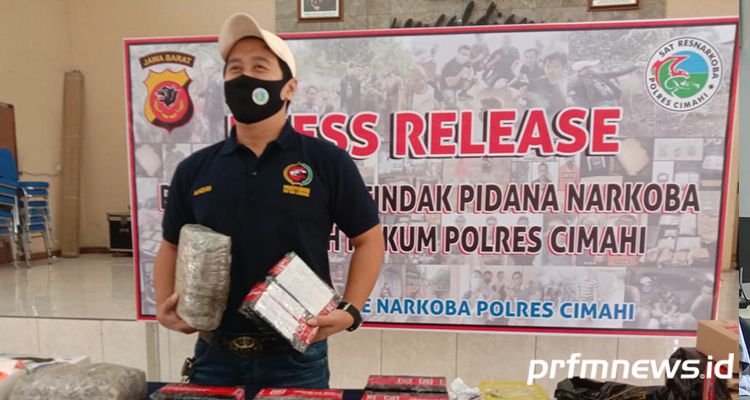Kasat Narkoba Polres cimahi AKP Andri Alam Wijaya saat memperlihatkan barang bukti daun ganja yang dijual pelaku MD.**
