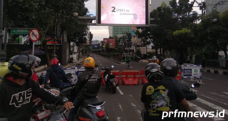 Warga menyaksikan petugas saat mengevakuasi pria yang mendadak pingsan di Jalan  Merdeka Kota Bandung, Kamis (21/5/2020)