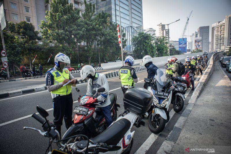 Polisi lalu lintas menilang para pengendara sepeda motor yang tidak menggunakan helm