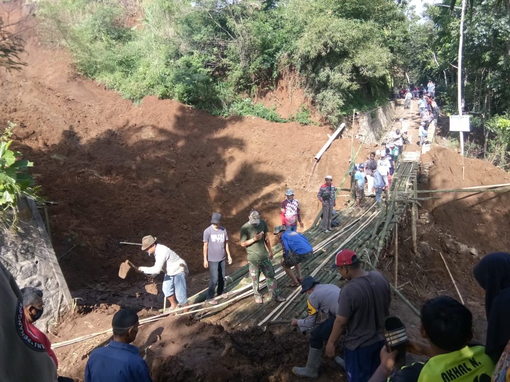 WARGA bersama TNI dan Polri bergotong royong membangun jembatan darurat di Desa Bugel Kecamatan Ciawi Kabupaten Tasikmalaya, Jumat, 12 Juni 2020.*