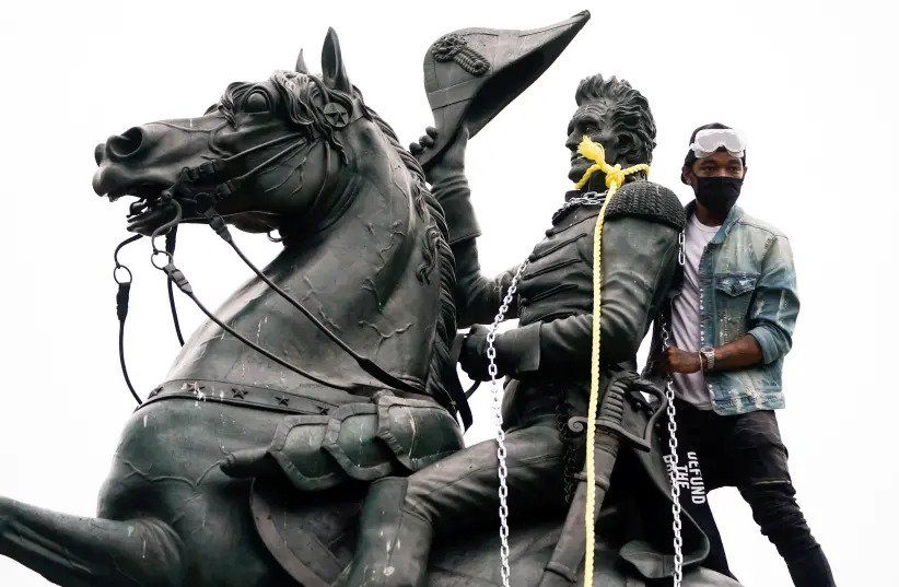 SEORANG pendemo terlihat berada di atas patung Andrew Jackson yang telah diikatkan tali pada aksi protes di dekat Gedung Putih.*