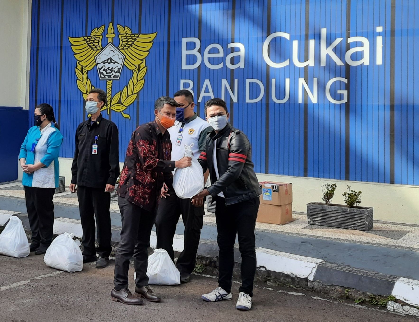 Ketua APKB Cabang Bandung Iwa Koswara (berkemeja batik) secara simbolis menyerahkan bantuan paket sembako kepada perwakilan pengurus warga RW 07 Babakan Penghulu, Cinambo. /DIDIH HUDAYA