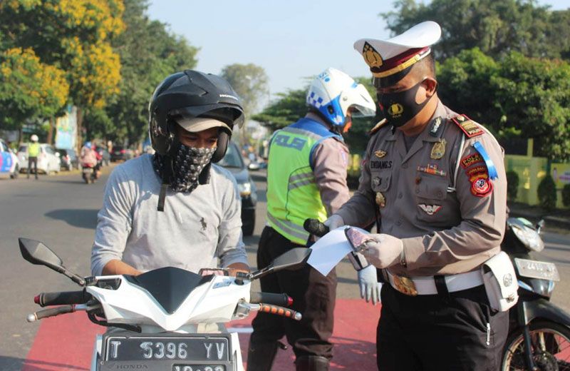 Kasatlantas Polres Subang, AKP EndangSujana saat memberikan masker ke pengguna sepeda motor saat pelaksanaan Operasi Patuh Lodaya 2020. (Foto: Dally Kardilan/Galamedia)