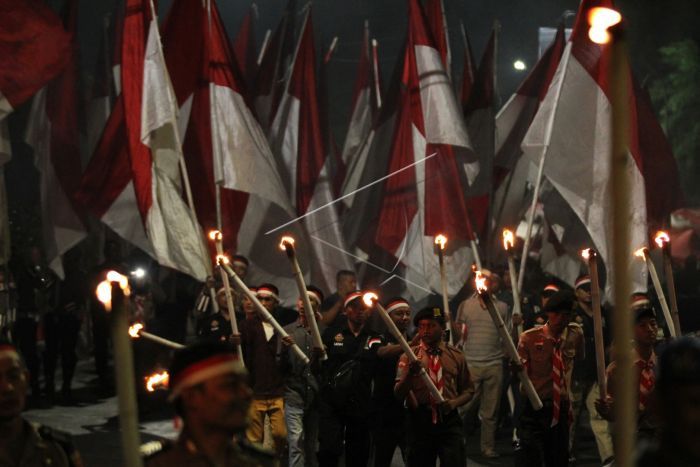 Anggota polisi, TNI dan warga membawa Bendera Merah Putih saat Parade Merah Putih di Jalan Kebon Rojo, Surabaya, Jawa Timur, Jumat (8/11/2019) malam. Kirab Bendera Merah Putih sepanjang 500 meter itu untuk memperingati Hari Pahlawan. ANTARA FOTO/Didik Suhartono/aww.