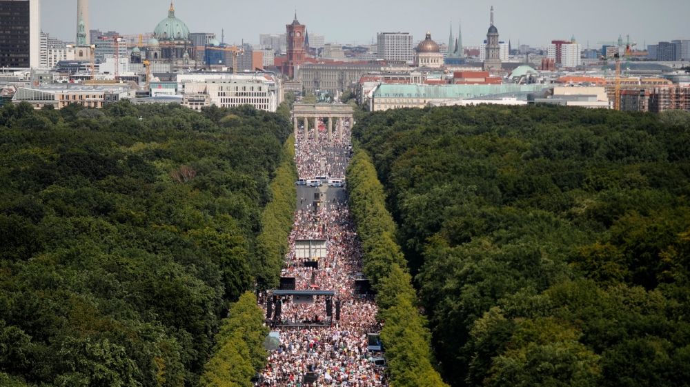 Orang-orang berkumpul di gerbang Brandenburg untuk memprotes pembatasan coronavirus [Markus Schreiber / The Associated Press]