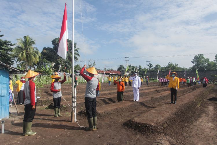 Sejumlah anggota kelompok tani sumber rejeki bertugas mengibarkan bendera Merah Putih di lahan kebun mereka di Jalan Betutu, Palangkaraya, Kalimantan Tengah, Senin (17/8/2020).