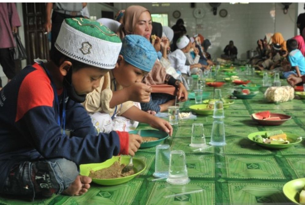 Sejumlah anak yatim dan warga sekitar menikmati sajian bubur sop dan penganan lainnya di Masjid Suro Palembang, Sumsel, Sabtu (29/8/2020).