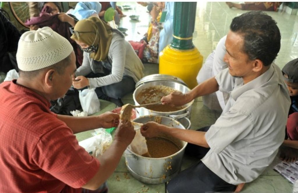 Petugas membungkus bubur sop untuk dibagikan kepada warga di Masjid Suro Palembang, Sumsel, Sabtu (29/8/2020). Setiap tanggal 10 Muharram Masjid Suro menjalankan tradisi menjamu puluhan anak yatim dan membagikan bubur sop kepada warga sekitar.