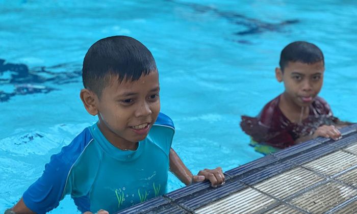 Seorang anak dari panti asuhan Tambatan Hati tengah berenang di Hotel Horison Ultima