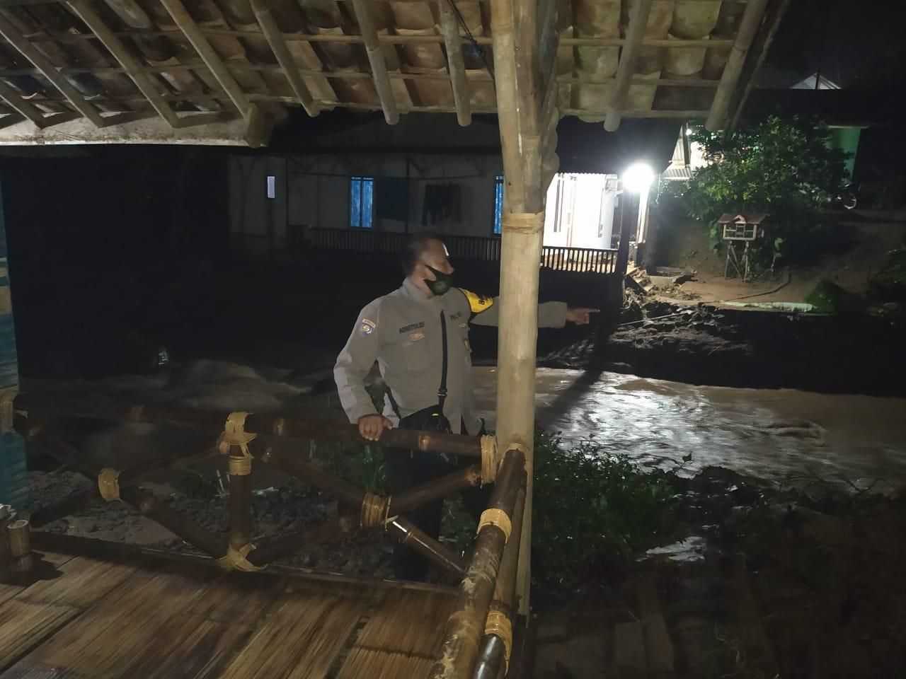 Seorang anggota Polsek Nanggung melihat kondisi bekas banjir bandang yang merendam 5 rumah dan memutus 2 jembatan di Kampung Citalahab Sentral, Desa Wisata Malasari, Nanggung, Kabupaten Bogor, Kamis 3 September 2020.