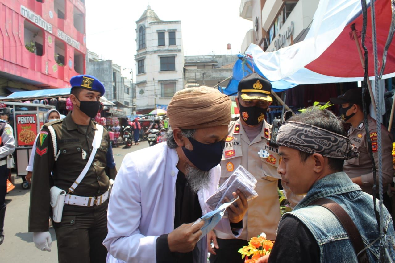 Para ulama membagi bagikan masker kepada warga
