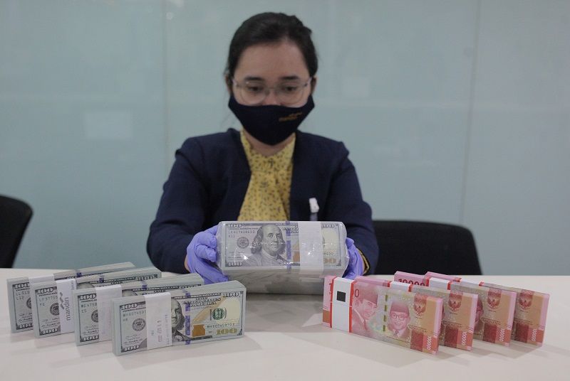 Karyawati menghitung uang rupiah dan dollar AS di salah satu bank di Jakarta.  Berdasarkan data Bloomberg, penutupan Selasa sore (15/9), kurs rupiah akhirnya ditutup pada level Rp14.845 per dollar AS. 