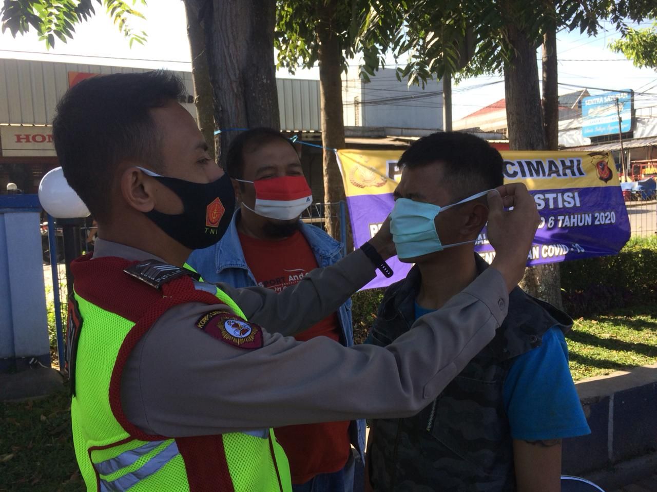 Petugas gabungan saat membentu memasangkan masker pada warga dalam Operasi Yustisi hari ke-6 di Lembang, Senin 21 September 2020.