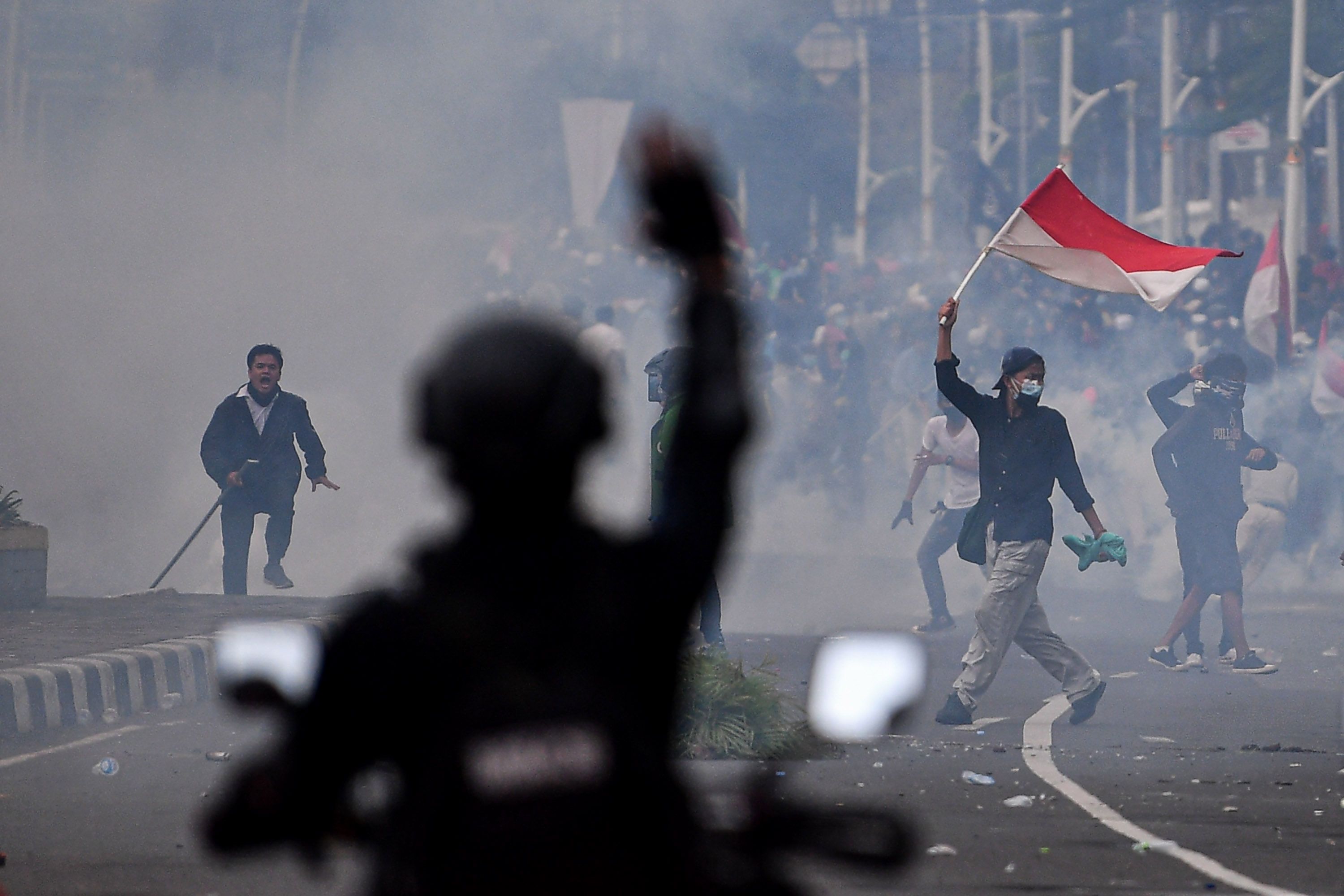 Massa aksi penolak UU Cipta Kerja mengibarkan bendera Merah-Putih di Tugu Tani, Jakarta Pusat, Selasa 13 Oktober 2020. 