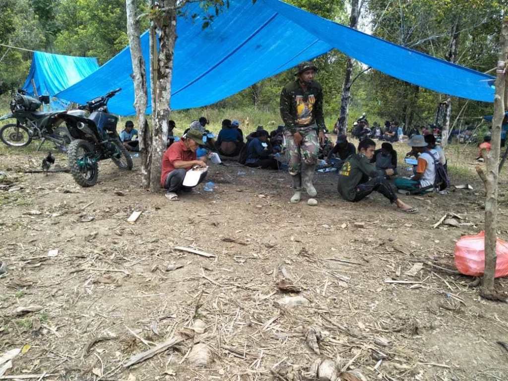 Prajurit TNi dan warga makan siang bersama di bawah tenda.*