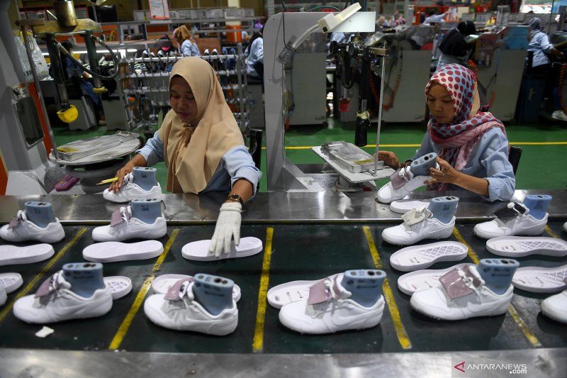 Ilustrasi pekerja sedang memproduksi sepatu.*