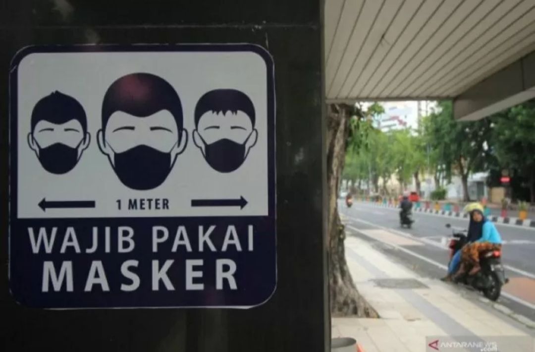 Rambu 'Wajib Pakai Masker' terpasang di halte bus di Jalan Panglima Sudirman, Surabaya, Jawa Timur.