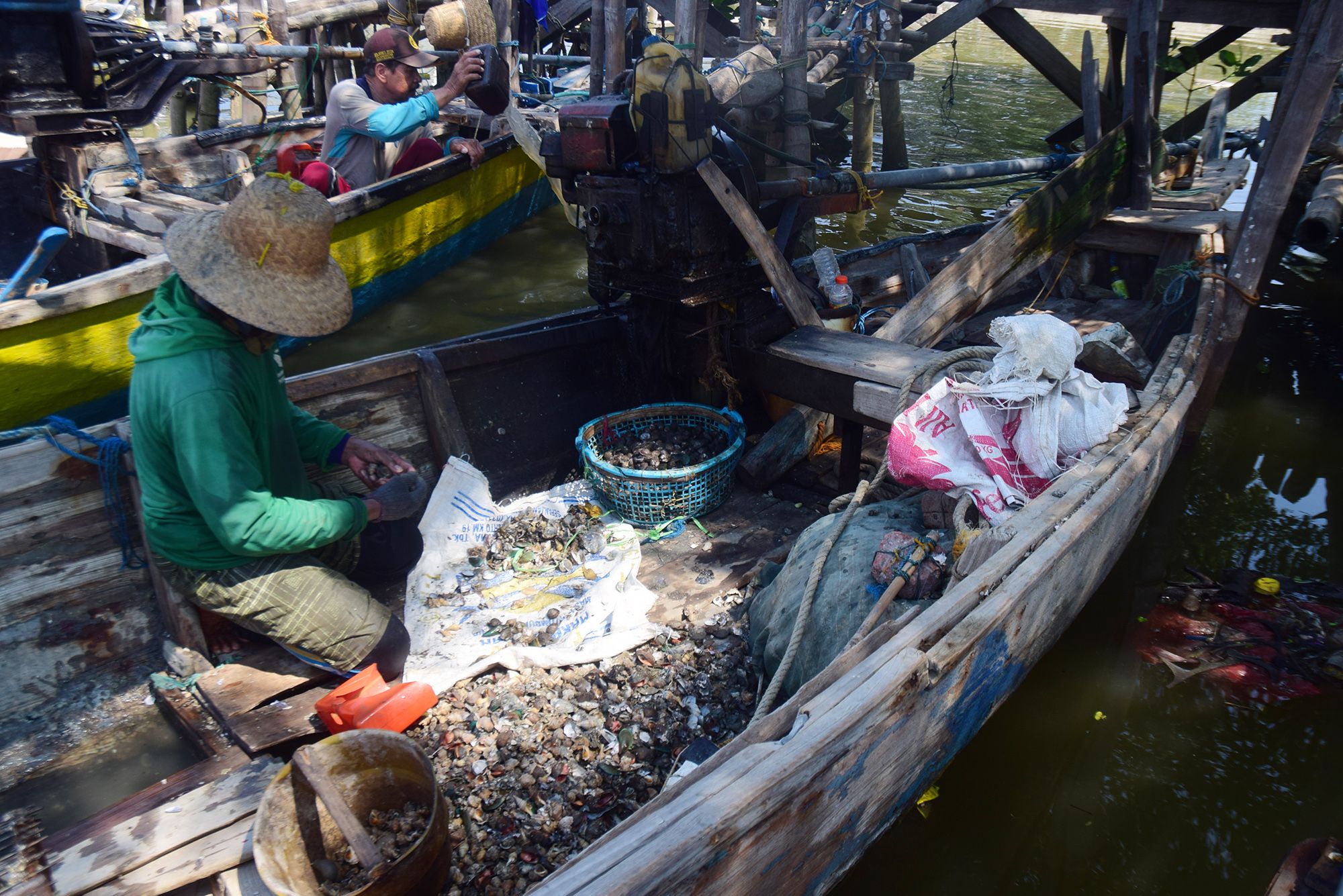 Nelayan memilah kerang di atas perahu di Gisik Cemandi, Sidoarjo, Minggu (15/11).