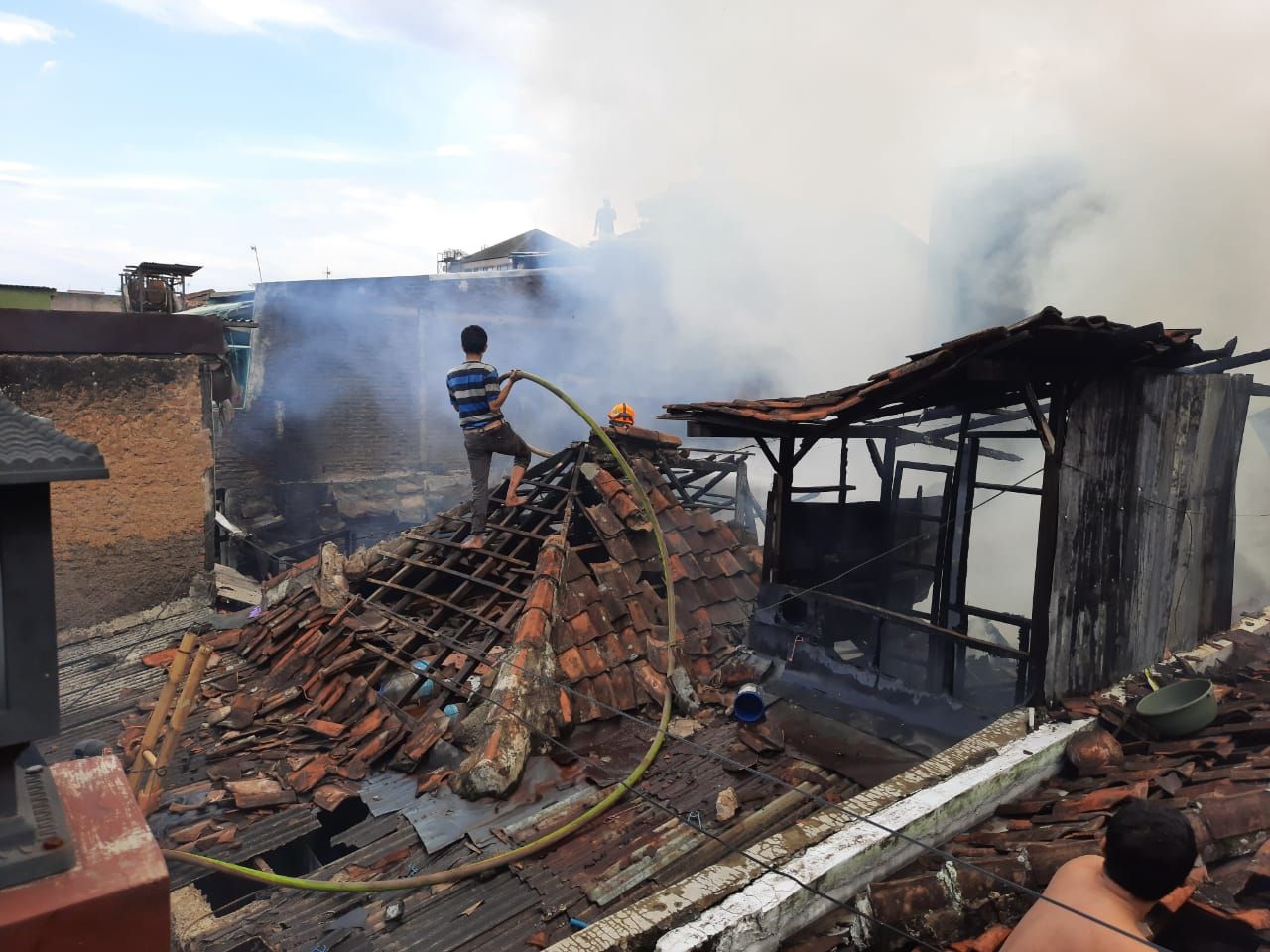 Warga ikut membantu proses pemadaman dalam peristiwa kebakaran rumah di Jalan Pagarsih, Kelurahan Jamika, Kecamatan Bojongloa Kaler, Kota Bandung, Minggu 15 November 2020 sore.