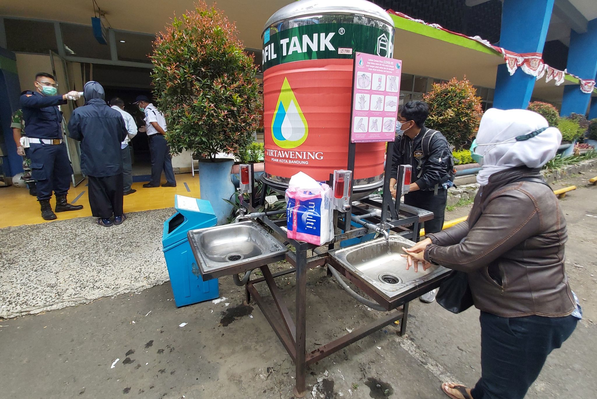 Pelanggan mencuci tangan sebelum memasuki ruang pelayanan di PDAM Tirtawening Kota Bandung, Jalan Badak Singa, Rabu 18 November 2020.