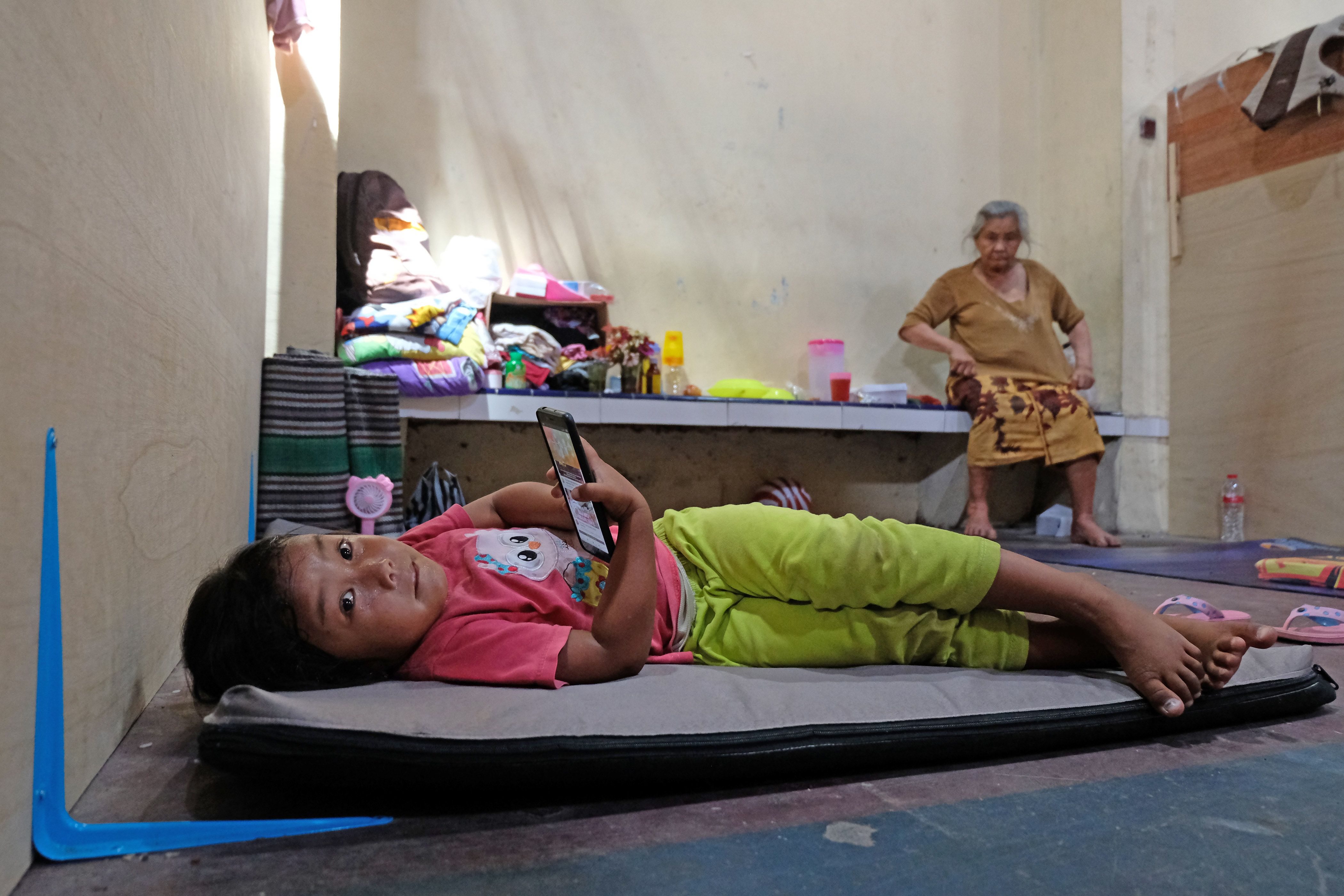 Seorang anak pengungsi bermain gawai di tempat pengungsian Merapi Desa Deyangan, Magelang, Jateng, Rabu (18/11/2020).  Pemerintah Kabupaten Magelang melalui belanja tak terduga (BTT) mengalokasikan anggaran Rp5 miliar untuk penanganan bencana Gunung Merapi. ANTARA FOTO/Anis Efizudin/aww.
