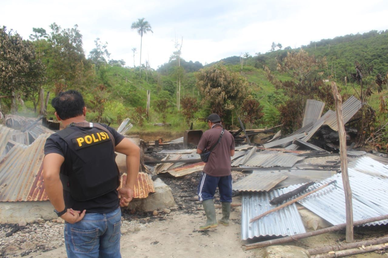 Polisi memeriksa bangunan yang dibakar dalam serangan yang diduga dilakukan oleh kelompok teroris Mujahidin Indonesia Timur (MIT) pimpinan Ali Kalora di Dusun Lewonu, Desa Lemban Tongoa, Kecamatan Palolo, Kabupaten Sigi, Sulawesi Tengah, Sabtu (28/11/2020). Serangan yang diduga dilakukan kelompok teroris MIT pimpinan Ali Kalora yang terjadi pada Jumat (27/11/2020) tersebut menewaskan empat orang warga, beberapa rumah warga dibakar dan mengakibatkan warga mengungsi ke tempat yang aman. Hingga kin