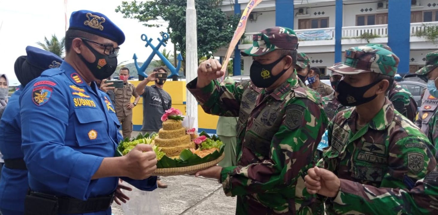 Komandan Pos TNI AL Pangandaran Kapten Laut Toto Sukarto sedang menyerahkan nasi tumpeng kepada Kasat Pol Air Polres Ciamis AKP Sugianto