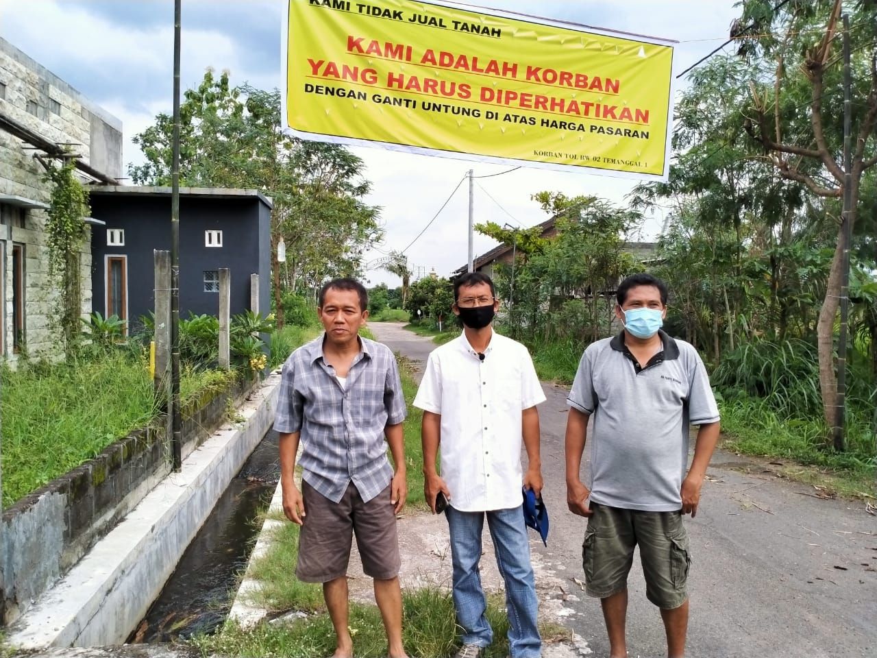 Iwan Setiawan (kanan), Handoko (tengah) dan Budi Santoso, berdiri di lokasi calon jalan tol di wilayah RT 04/RW 02 Dusun Temanggal I, Desa Purwomartani, Kecamatan Kalasan, Kabupaten Sleman, Minggu (6/12/2020). 