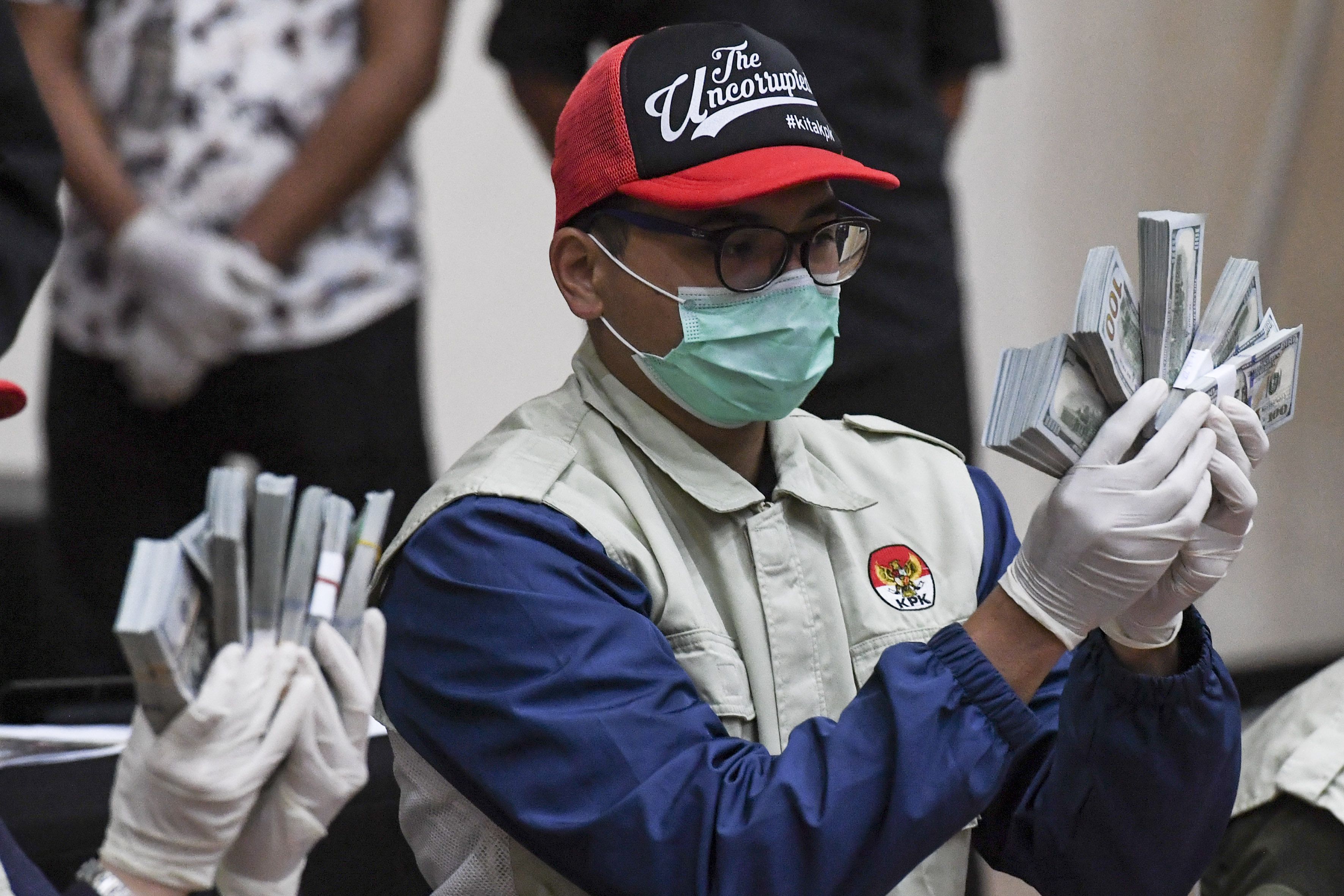 Penyidik KPK menunjukan barang bukti uang tunai saat konferensi pers terkait Operasi Tangkap Tangan (OTT) tindak pidana korupsi pada program bantuan sosial di Kementerian Sosial untuk penanganan COVID-19 di Gedung KPK, Jakarta, Minggu 6 Desember 2020 dini hari. 