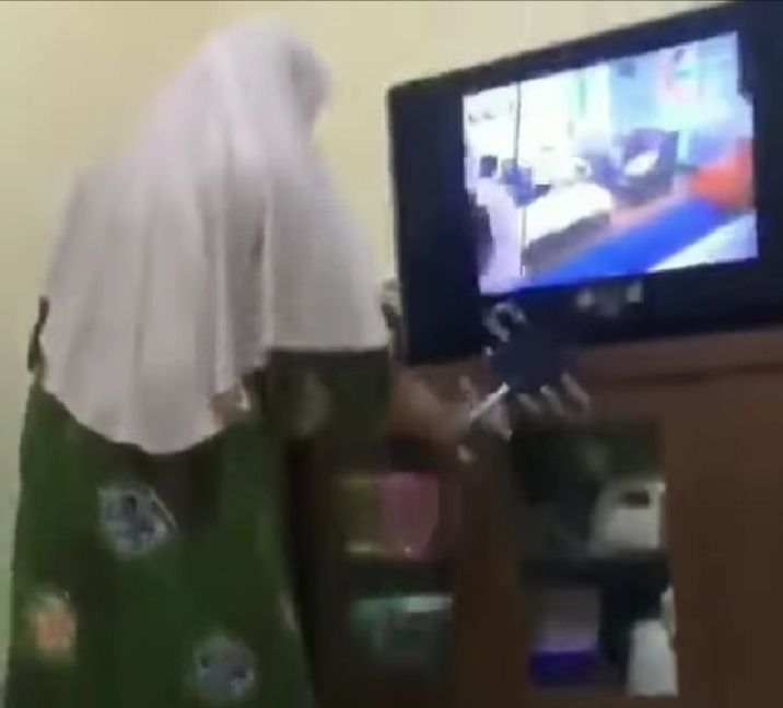 Tangkapan layar aksi emak-emak melampiaskan emosinya pada sebuah televisi