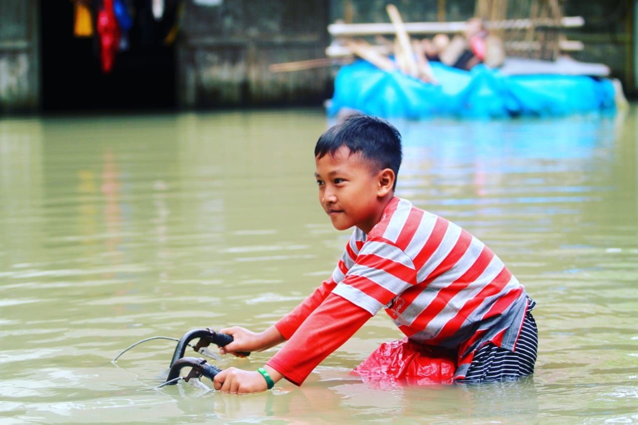 Seorang anak menaiki sepedanya di wilayah yang terdampak banjir kecamatan Butuh, kabupaten Purworejo.