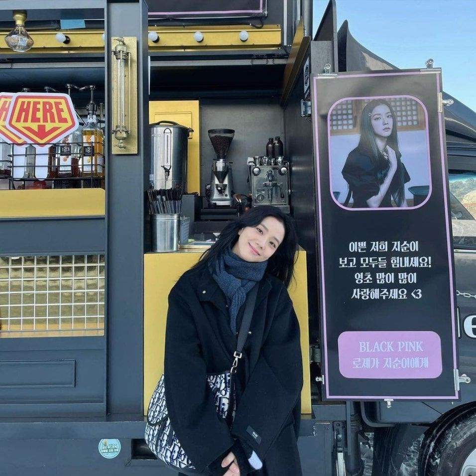 Jisoo tersenyum di depan kiriman coffee truck dari Rosé. (Instagram/sooyaaa__)