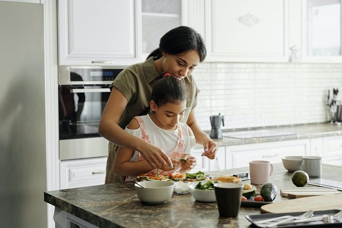 lustrasi interaksi Ibu dan anak yang sedang memasak bersama.