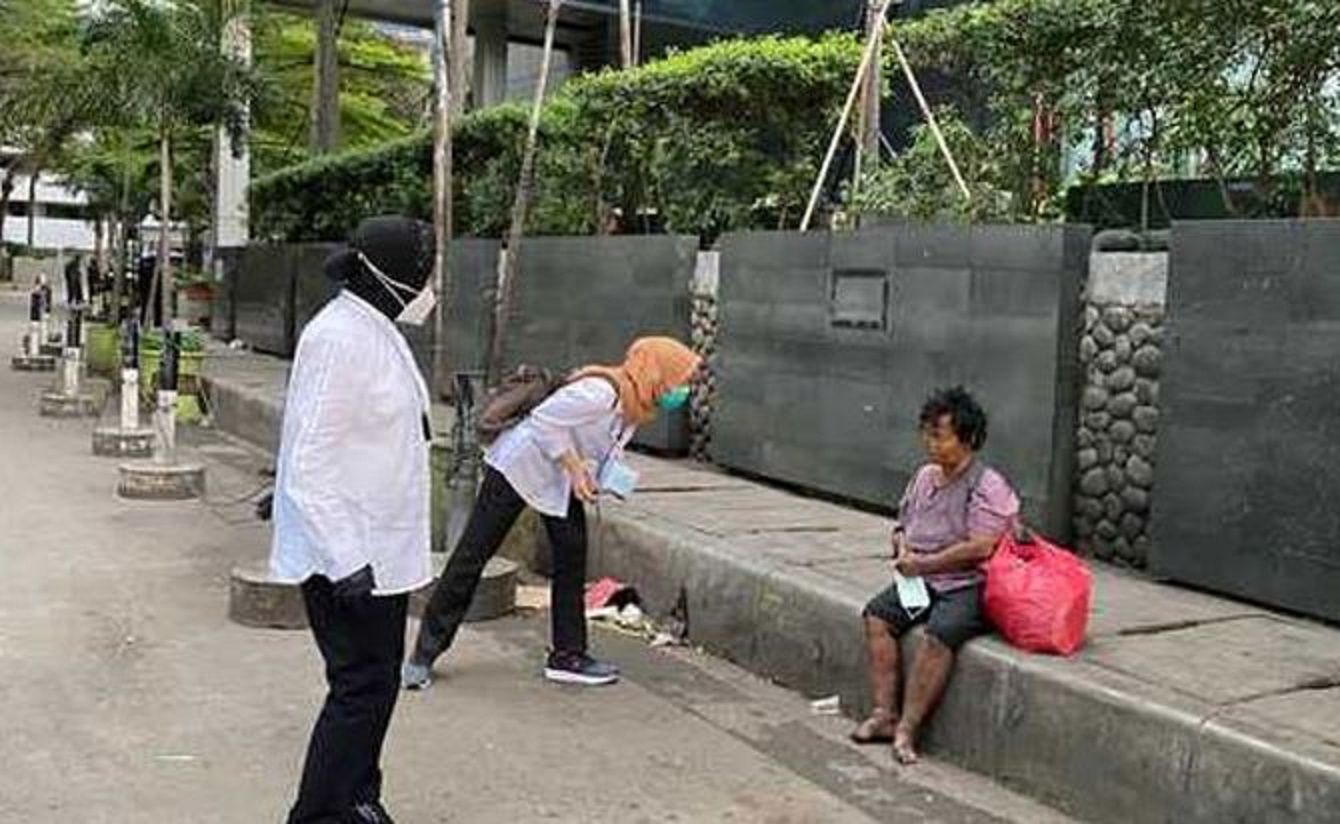 Menteri Sosial, Tri Rismaharini (kiri) saat mengajak berdialog tuna wisma di jalan.   Gubernur DKI Jakarta, Anies Baswedan langsung memerintahkan aparatnya mencari dan mencek identitas para pengemis dan pemulung yang ditemui Mensos Risma.